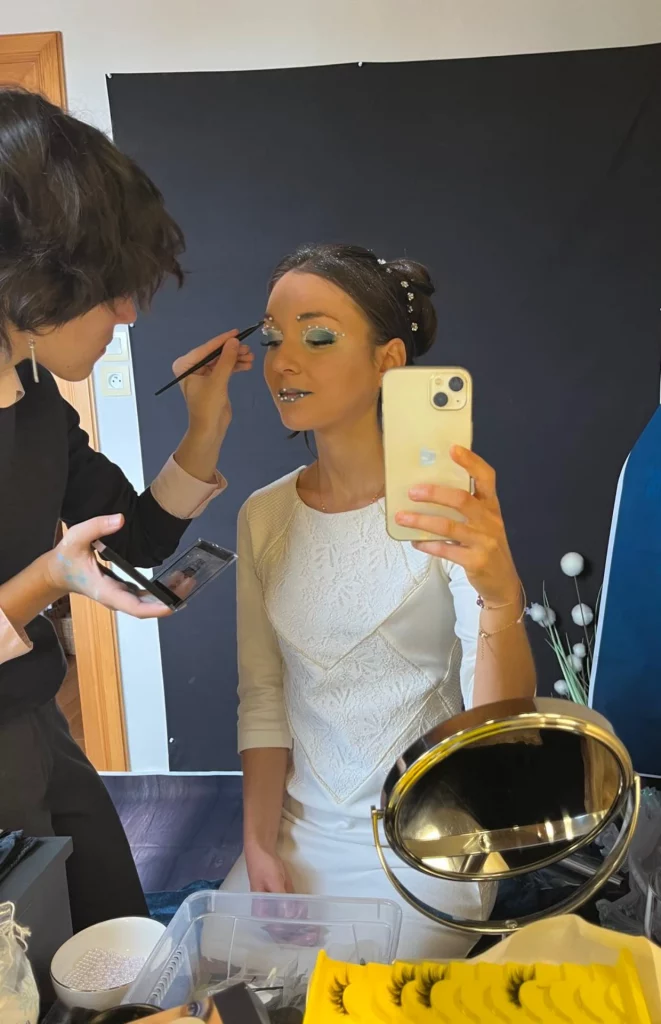 Math David Makeup qui réalise un maquillage éditorial sur une jeune femme.