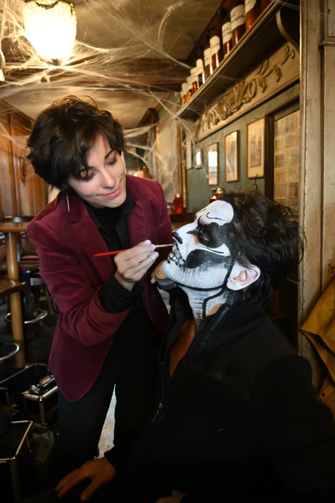 Math David peint debout, un motif noir et blanc sur le visage d'un employé du Darwin en Alsace.