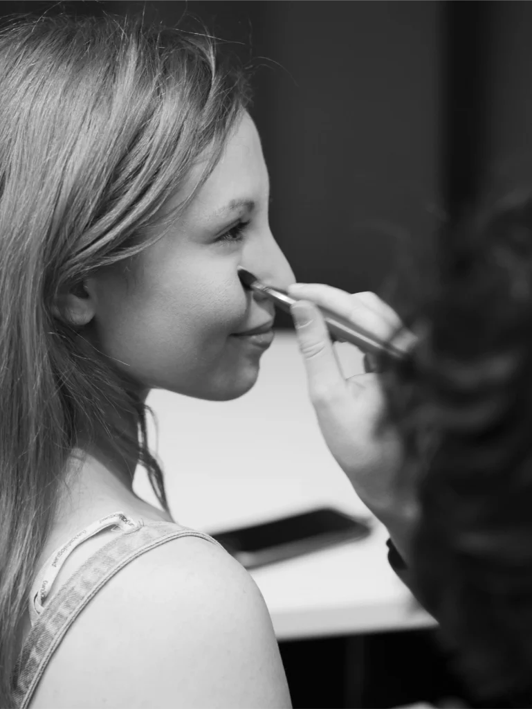 Gros plan sur le visage d'une modèle se faisant maquiller.