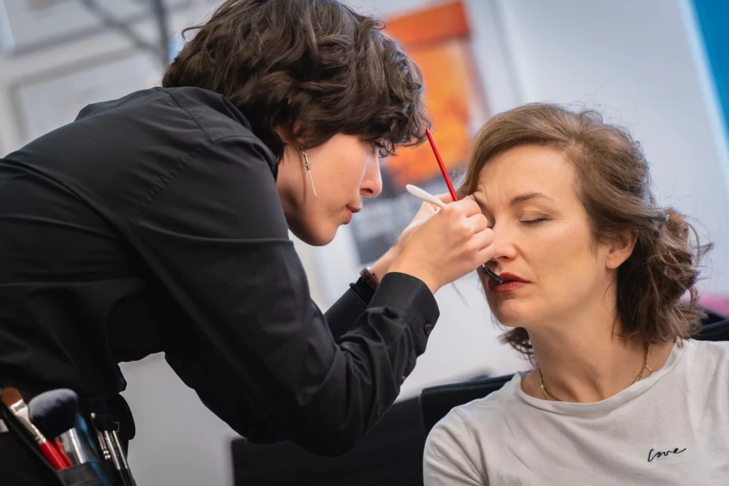 Math David makeup concentrée dans les loges du tournage, à appliquer du mascara sur l'actrice pricipale