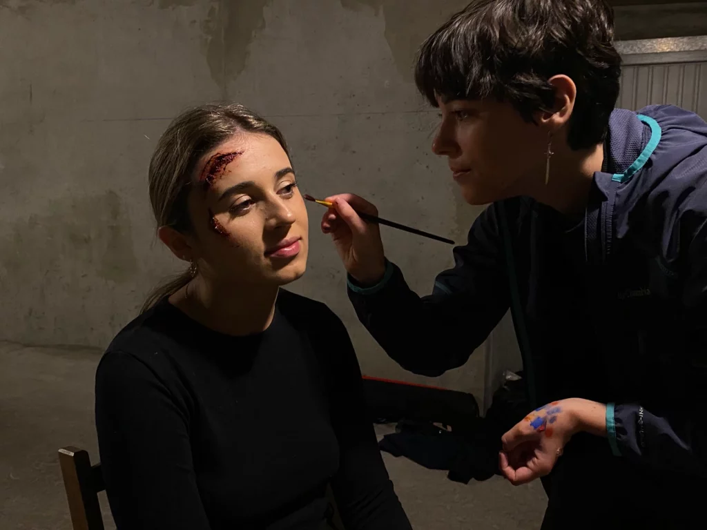 Math David Makeup réalisant un maquillage SFX sur une jeune femme.