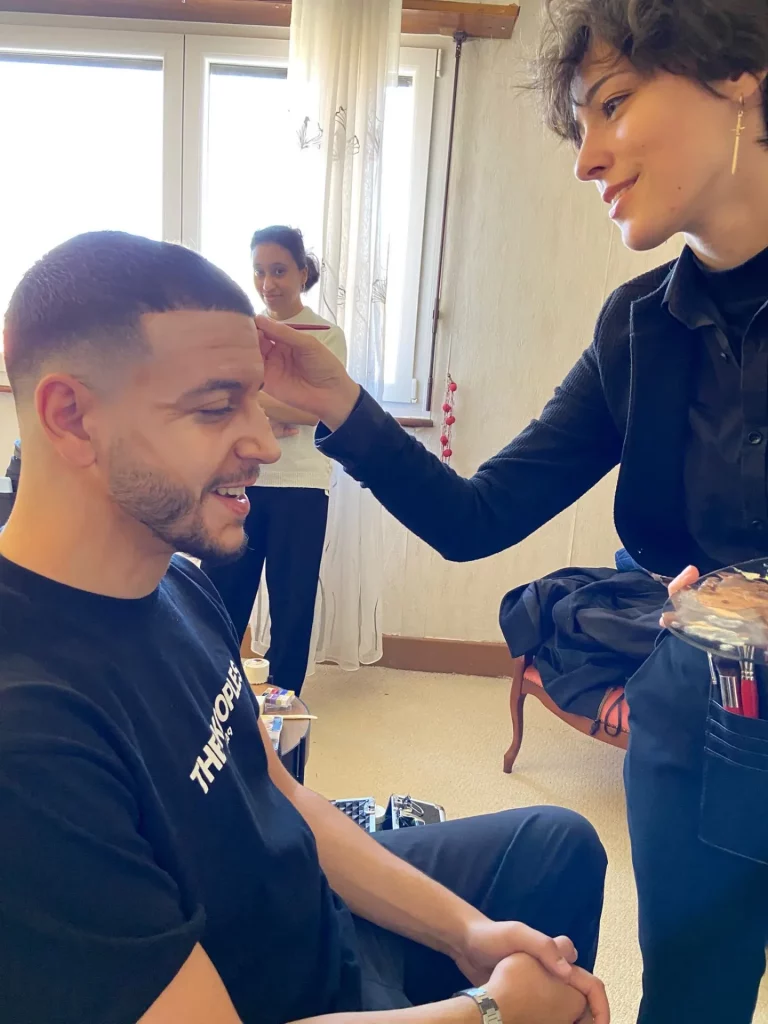 Math David Makeup dans les backstage d'un tournage réalisant un vieillissement du visage sur un homme.