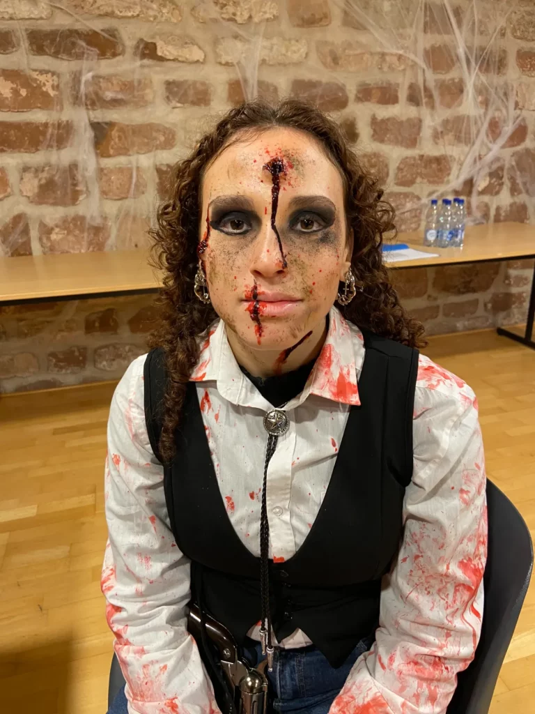 Modèle avec un maquillage SFX ensanglanté et un impact de balle dans le front