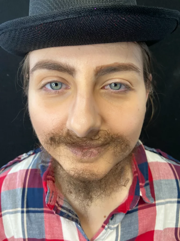Gros plan sur le visage de face d'une modèle avec une fausse barbe
