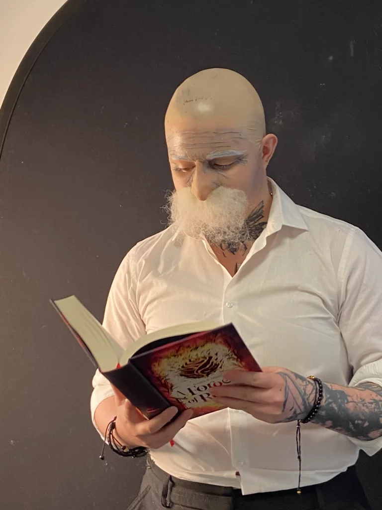 Modèle avec un faux crâne et une fausse moustache implantée, lisant un livre