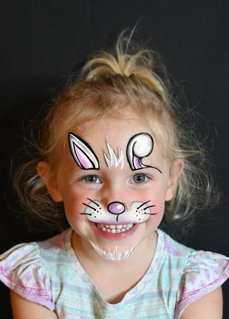 Un enfant souriant avec un maquillage représentant un lapin mignon.