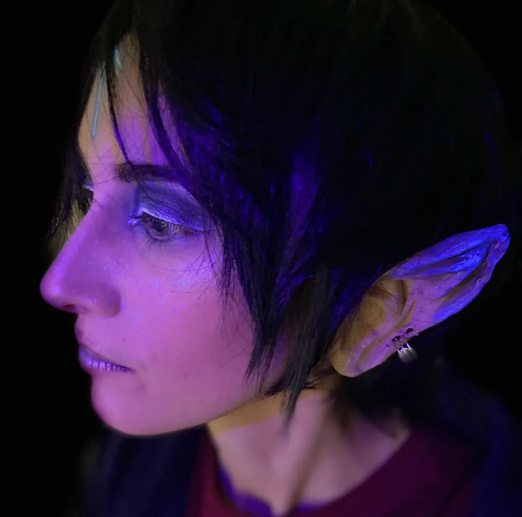 Gros plan sur un maquillage elfique portant une prothèse d'oreille.