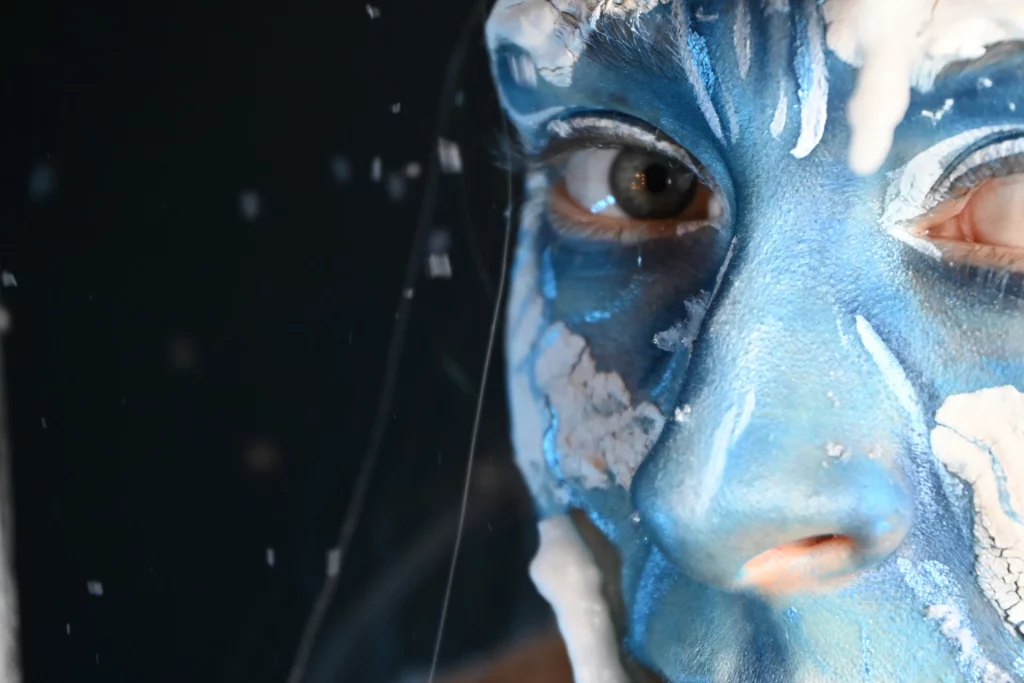 Gros plan sur le visage du modèle, maquillée d'une peau bleue et des détails de givres en relief sur la peau.