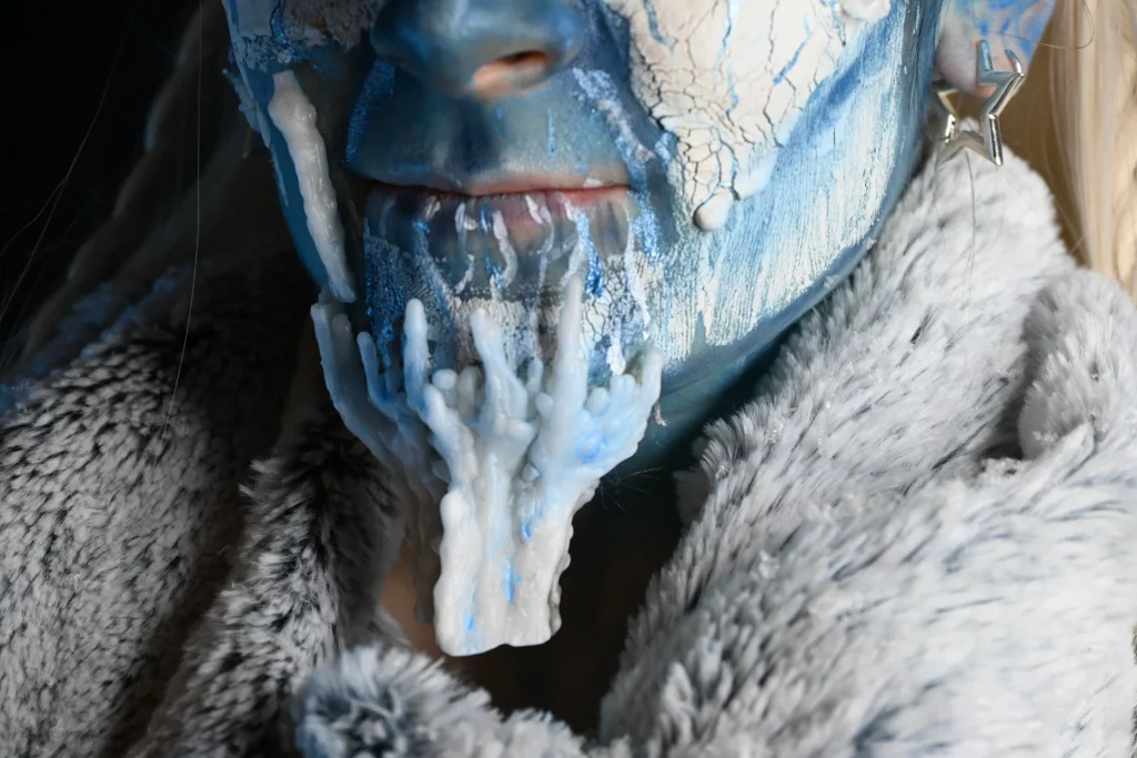 Focus sur le détail d'un maquillage d'une créature des glaces, avec une prothèse de menton en relief effet glace.
