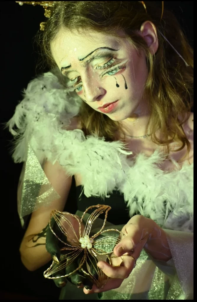 Une jeune femme avec de longs cils et un effet trompe l'oeil avec des yeux sur les joues.