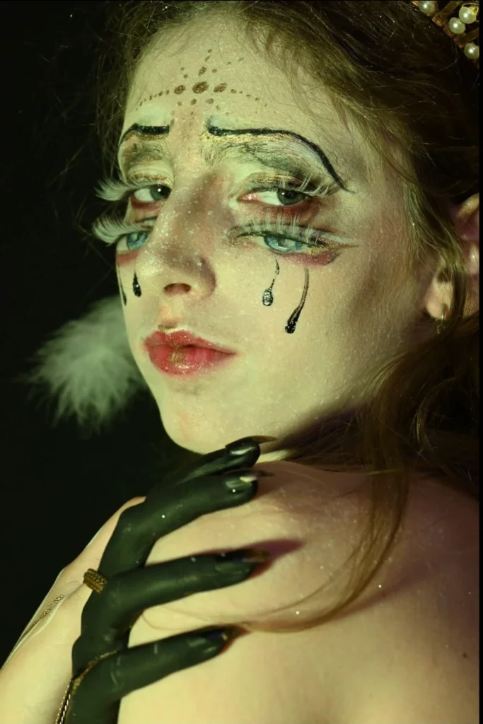 Portrait rapproché d'une femme avec des yeux en trompe l'oeil sur les joues et des larmes dessinées.