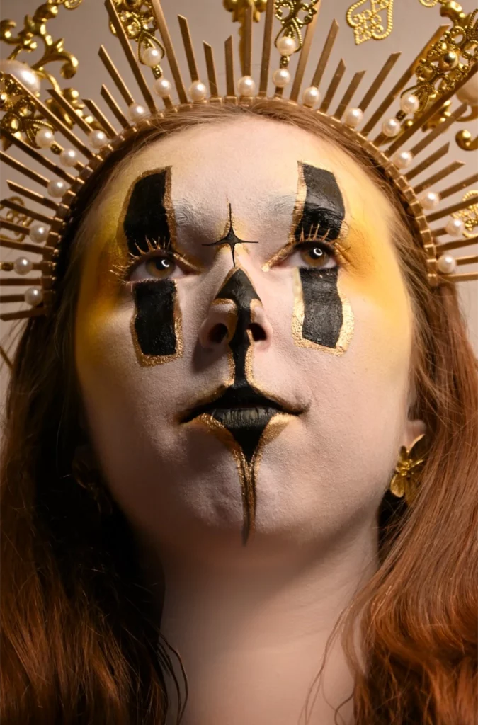 vue contre plongé avec un maquillage de facepaiting blanc et doré auréole et yeux ont rectangle noirs